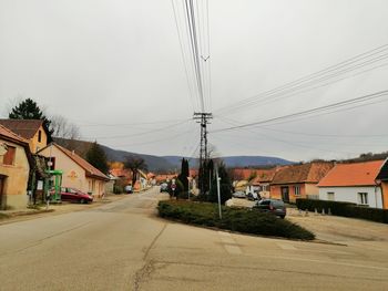 Houses by road against sky in city