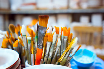Close-up of various paintbrushes in container