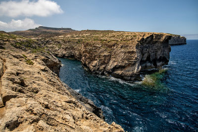 Rock formations by sea against sky