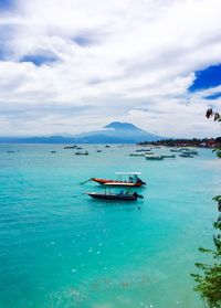 Boat in sea against cloudy sky