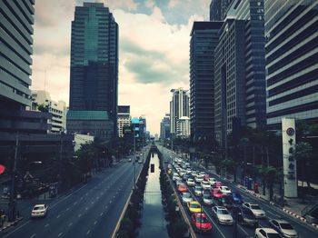 Traffic on city street amidst buildings against sky