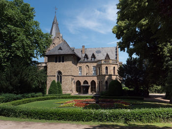 Lawn by building against sky