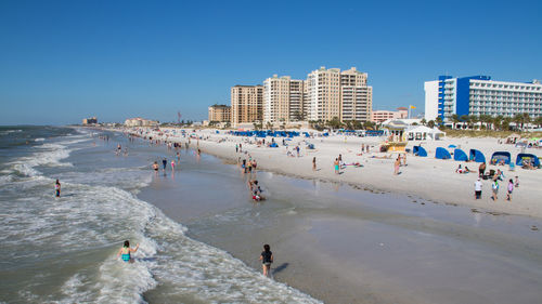 People on beach against clear sky