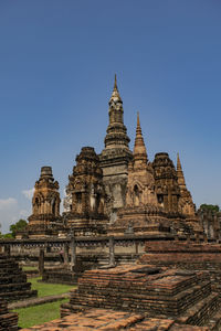 Low angle view of ruined pagoda against clear blue sky