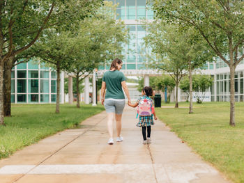 Young millennial mother sending daughter off back to school