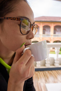 Close-up of woman holding sunglasses