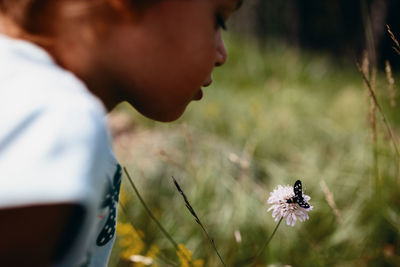 Child looking a butterfly on a flower. peaceful nature moment.