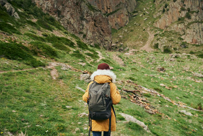 Rear view of man and woman walking on mountain road