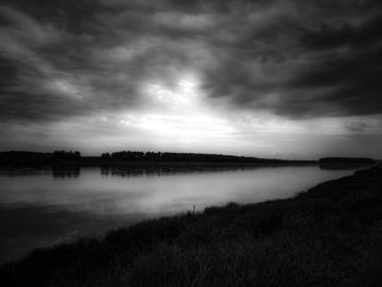 Scenic view of lake against sky at dusk