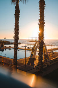 Bridge over sea against clear sky during sunset