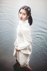 Portrait of a smiling young woman standing in lake