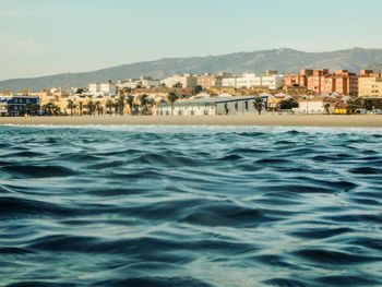 Scenic view of sea and buildings against clear sky