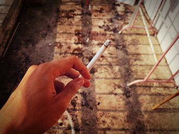 Close-up of hand holding cigarette