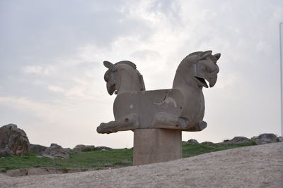 Low angle view of statue against rock