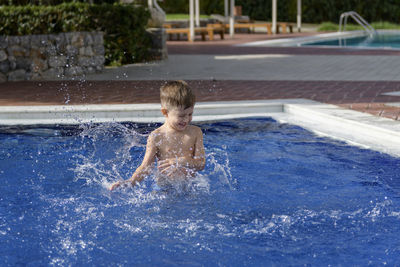 Full length of shirtless boy in swimming pool