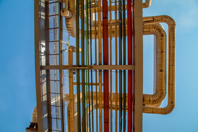 Low angle view of pipe against clear blue sky