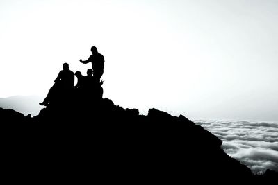 Silhouette men on landscape against mountain