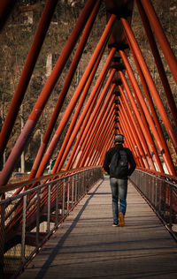 Rear view of man standing on footbridge