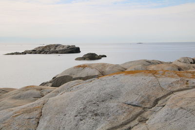 Scenic view of rocks on beach against sky