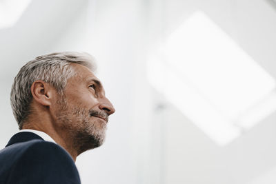 Confident mature businessman looking up