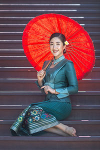 Portrait of a smiling young woman holding umbrella