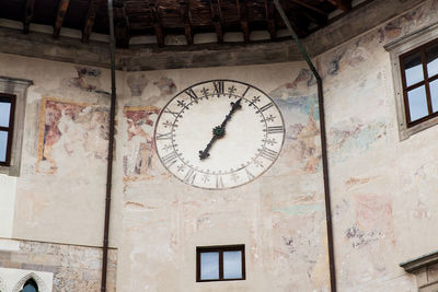 Low angle view of clock on building wall