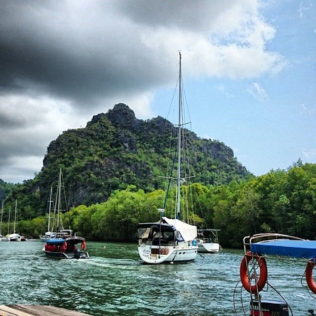 transportation, nautical vessel, mode of transport, boat, water, sky, tree, mountain, cloud - sky, moored, cloudy, waterfront, river, mast, cloud, travel, nature, sailing, scenics, beauty in nature