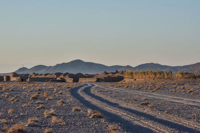 Scenic view of field against clear sky road directing inside the village