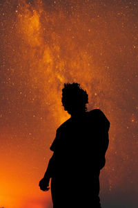 Silhouette man standing against sky at night