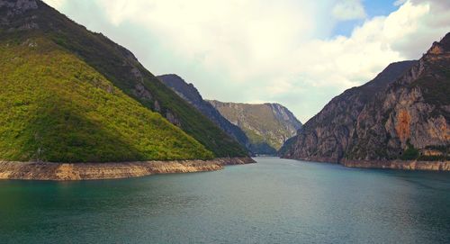 Scenic view of river and mountains against sky