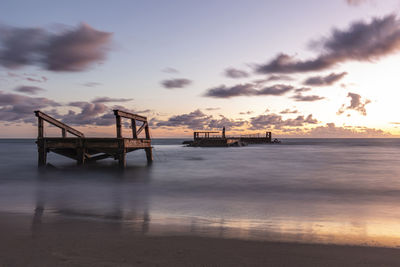 Silhouette pier on sea against sky during sunset