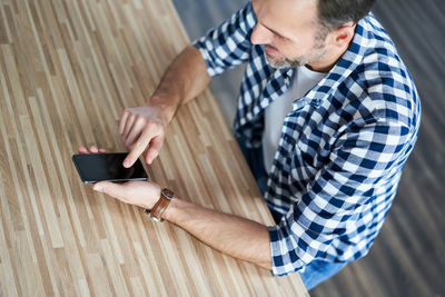 Midsection of man using mobile phone