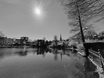 Scenic view of river by buildings against sky