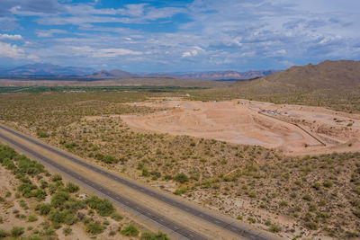 Scenic view of road amidst field against sky