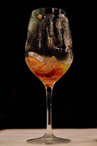 Close-up of wineglass on table against black background