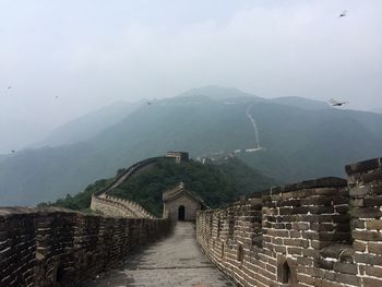 Great wall of china against sky in foggy weather