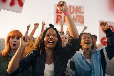 Happy women shouting for equal rights while marching together