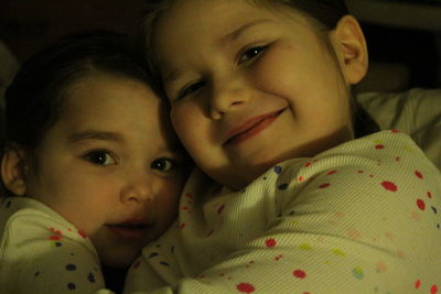 Close-up portrait of cute baby girl on bed at home