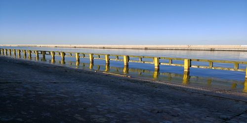 Pier over sea against clear sky