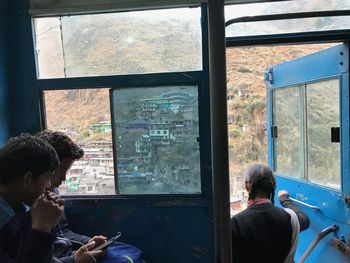 Rear view of people looking through window