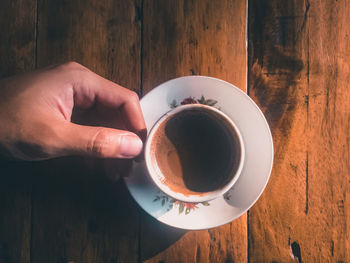 Person holding coffee cup on table