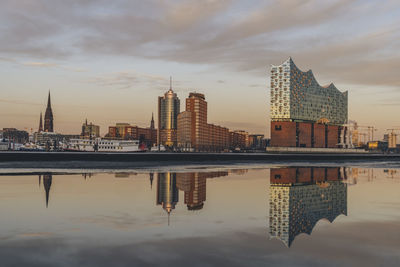 Germany, hamburg, elbphilharmonie reflecting in elbe river at dusk