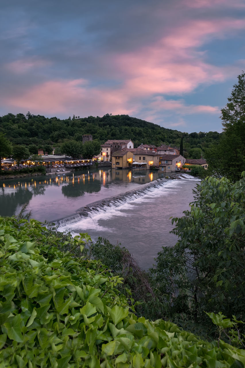 SCENIC VIEW OF RIVER BY BUILDINGS AGAINST SKY