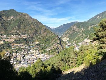 Scenic view of townscape and mountains against sky