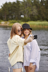 Two friends taking selfie at lakeside