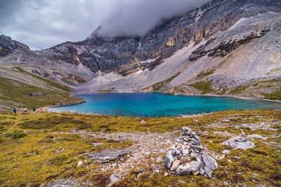 Scenic view of lake by mountains against sky