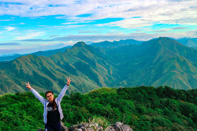 High angle view of woman gesturing while standing on mountain