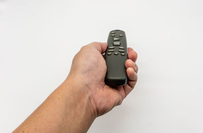 Close-up of hand holding camera over white background