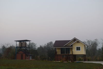 House on field against clear sky