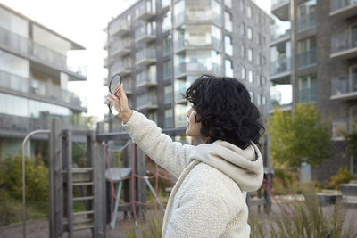 Teenage girl looking in mirror outdoors